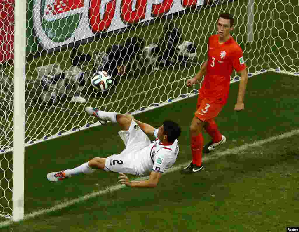 Costa Rica's Johnny Acosta clears the ball from the goalpost during extra time against Netherlands at the Fonte Nova arena in Salvador, July 5, 2014.