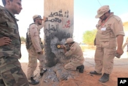 Des combattants du CNT en train de détruire la Porte orientale de Syrte qui séparait la ville natale de Kadhafi des villages de la région