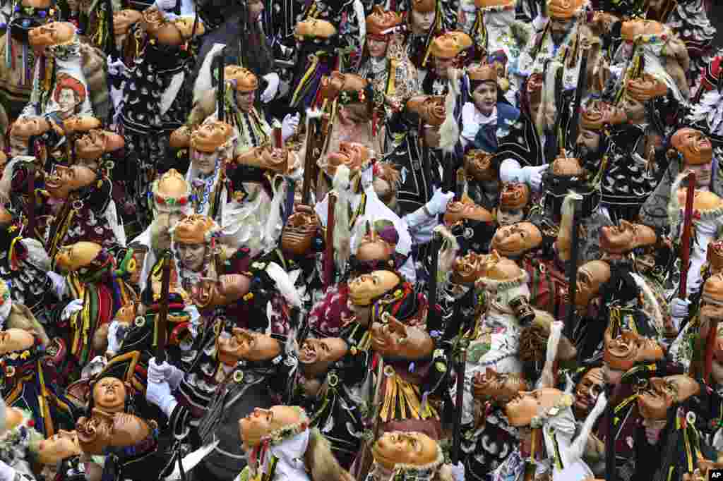 Masked revelers prepare to take part in the carnival in Rottweil, Germany.