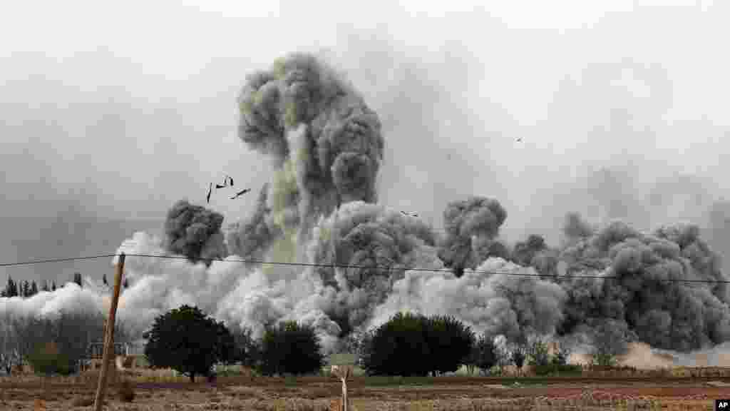 Epaisse fumée et débris s&#39;élèvent après une frappe de la coalition menée oar les Etats-Unis à Kobani, en Syrie, dimanche le 12 ocotbre 2014. (AP Photo/Lefteris Pitarakis) 