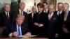 US President Donald Trump signs a presidential memorandum imposing tariffs and investment restrictions on China in the Diplomatic Reception Room of the White House, March 22, 2018, in Washington. 