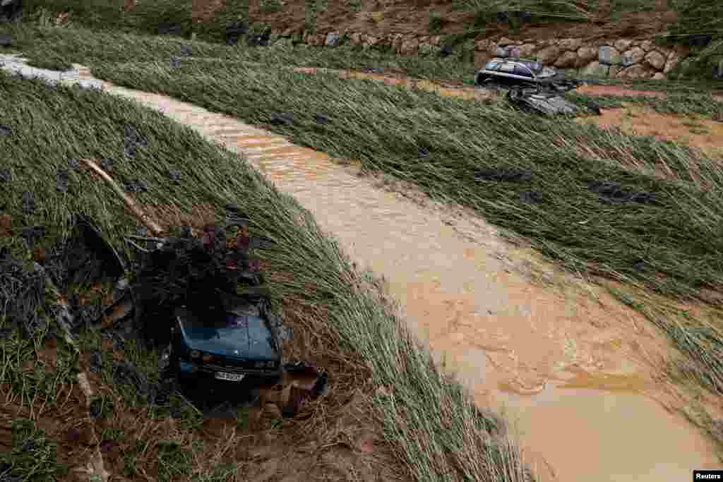 Cars lie on the riverbank after heavy rainfall in Tafalla, Spain.