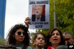 Activists, members of the Human Rights Association Istanbul branch, holding posters with photos of missing Saudi journalist Jamal Khashoggi, talk to members of the media, during a protest in his support near the Saudi Arabia consulate in Istanbul, Oct. 9, 2018.