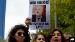 Activists, members of the Human Rights Association Istanbul branch, holding posters with photos of missing Saudi journalist Jamal Khashoggi, talk to members of the media, during a protest in his support near the Saudi Arabia consulate in Istanbul, Turkey, Oct. 9, 2018.