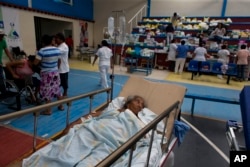 A 71-year-old woman, who was injured when a wall collapsed on her in Thursday's massive earthquake, receives treatment in a medical ward set up on a school's basketball court, in Juchitan, Oaxaca state, Mexico, Sept. 9, 2017. Juchitan General Hospital moved their operations to the basketball court after being devastated in the quake.