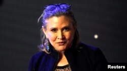FILE - Carrie Fisher poses for cameras as she arrives at the European Premiere of "Star Wars, The Force Awakens" in Leicester Square, London, Dec. 16, 2015. 