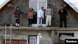 Warga berdiri di balkon lantai atas rumah mereka yang kebanjiran, menunggu dievakuasi dari kota Obrenovac, sebelah timur Belgrad, Serbia (16/5). (Reuters/Marko Djurica)