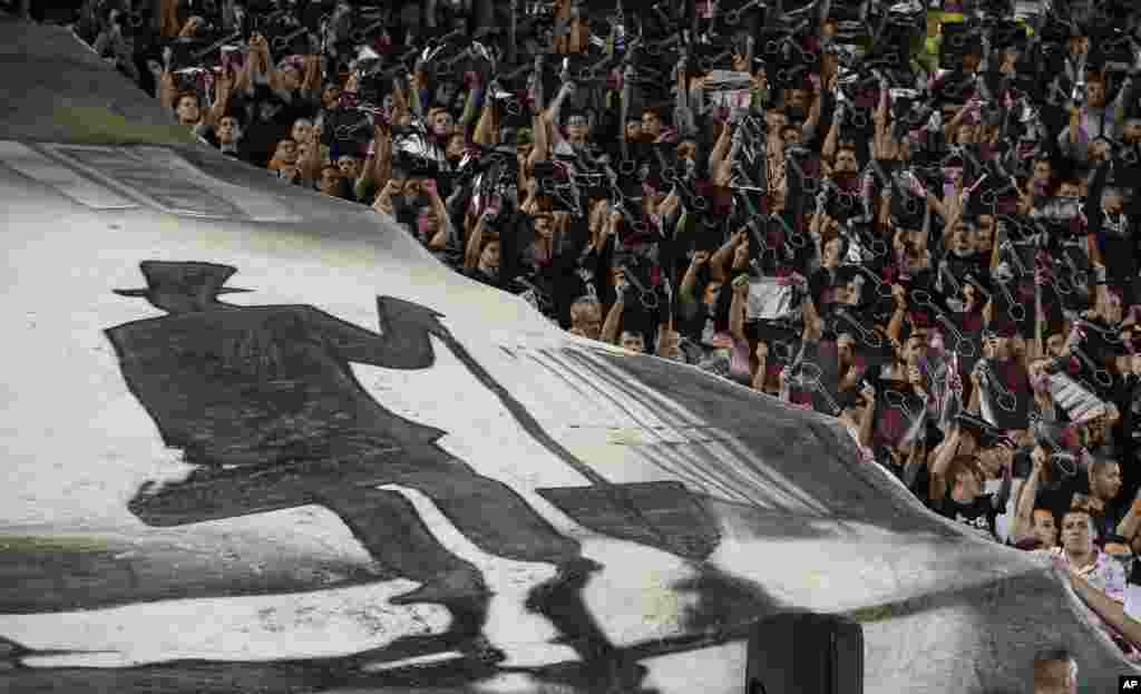 Partizan fans, known locally as Grobari, or the grave diggers, display posters with shovels on them before the Europa League group L soccer match between Partizan Belgrade and Manchester United at the Partizan stadium in Belgrade, Serbia.