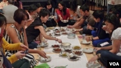 Diners pass around plates of spicy curry during a rendang tasting, an event held to educate people overseas about the popular dish and Indonesian culture, in Jakarta, Indonesia, August 4, 2012. (VOA - S. Schonhardt)