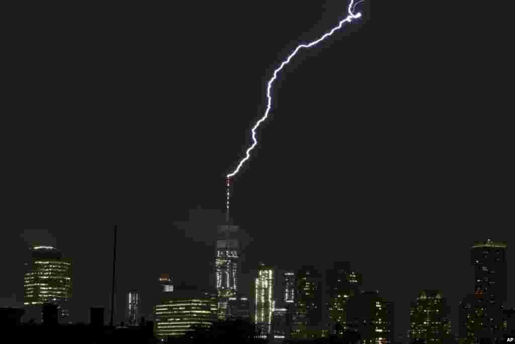 The bolt from a lightning storm hits the spire on top of the One World Trade Center tower in New York City, Aug. 22, 2017, seen from The Heights neighborhood of Jersey City, New Jersey.