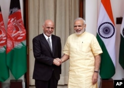 FILE - Indian Prime Minister Narendra Modi, right, shakes hand with Afghan President Ashraf Ghani, before a meeting in New Delhi, India, Wednesday, Sept. 14, 2016.