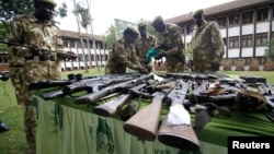 FILE - Kenya Wildlife Service officials inspect illegally held firearms recovered from poachers, at their headquarters in Kenya's capital Nairobi, June 22, 2012.