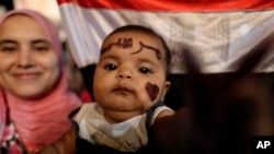 Một em bé sáu tháng tuổi với chữ Morsi bằng tiếng Ả rập viết trên trán