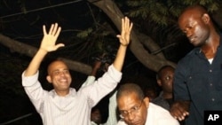 Haitian President-elect Michel Marthelly, left, reacts after the preliminary elections are announced, indicating he won the second round of the vote, in Peggyvillle, Haiti April 4, 2011