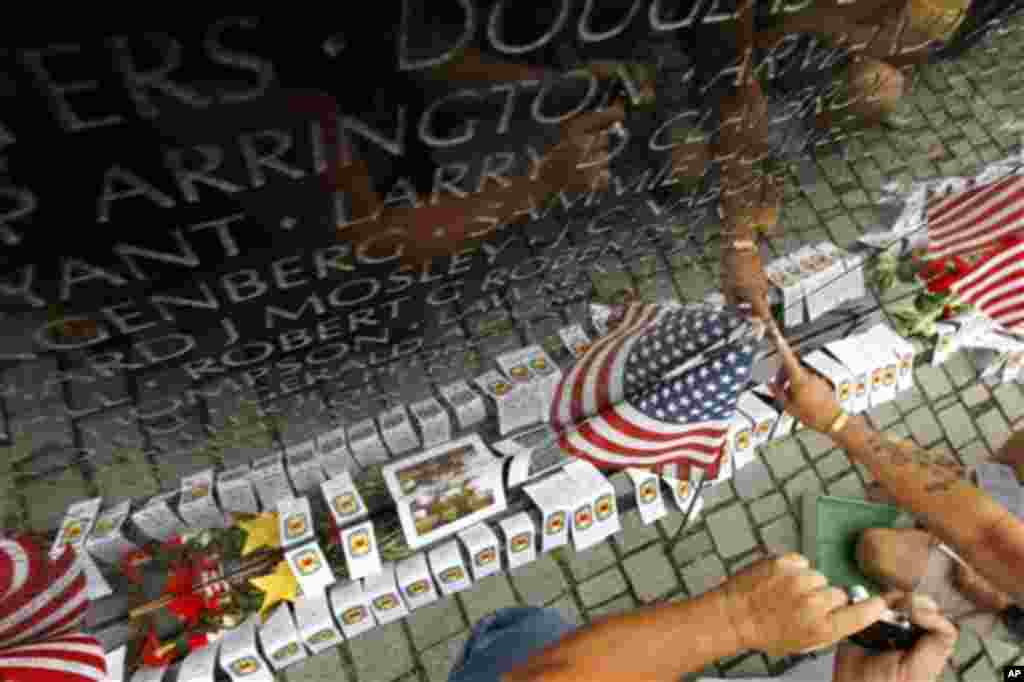 Visitors find a name on at the wall of the Vietnam Veterans Memorial in Washington on Sunday, May 29, 2011. Motorcyclists are in Washington for the traditional annual Rolling Thunder events during the Memorial Day weekend. (AP Photo/Jose Luis Magana)