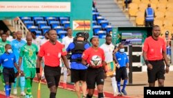 FILE - Referee Salima Mukansanga (center) with assistant referee's Lahsen Azgaou (left) and Oliver Kabene Safari (right) before the AFCON match between Zimbabwe and Guinea, January 18, 2022