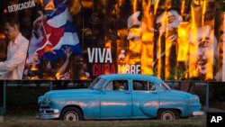 A taxi driving a classic American car passes a billboard that reads in Spanish: "Long live free Cuba" in Havana, Cuba, Monday, March 14, 2016. U.S. President Barack Obama will travel to Cuba on March 20. (AP Photo/Desmond Boylan)