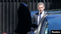 Former French President Nicolas Sarkozy (R) leaves his residence in Paris, July 2, 2014.