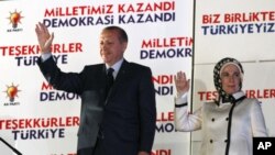 Prime Ministan Turkiya, Tayyip Erdogan da matarsa Emine, suke dagawa magoya bayansu hannu.