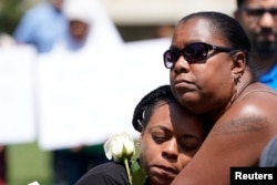 Dos mujeres participan en una vigilia de oración en Dayton, Ohio, después de un tiroteo que dejó 9 muertos y decenas de heridos. Agosto 4 de 2019. REUTERS/Bryan Woolston.