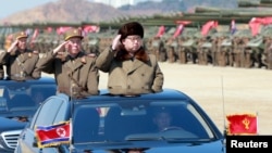 ຜູ້ນຳເກົາຫລີເໜືອທ່ານ Kim Jong Un ຄຳນັບ ໃນຂະນະທີ່ ກວດກາແຖວທະຫານ.