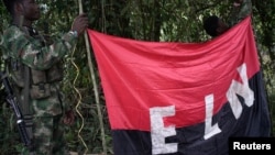 Rebels of the National Liberation Army hold a banner in the northwestern jungles in Colombia, Aug. 30, 2017.