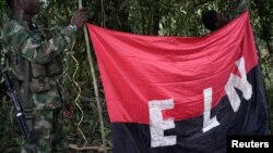 Rebels of the National Liberation Army hold a banner in the northwestern jungles in Colombia, Aug. 30, 2017.