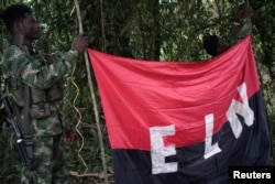 Rebels of the National Liberation Army hold a banner in the northwestern jungles in Colombia, Aug. 30, 2017.