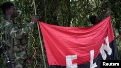 Rebeldes del Ejército de Liberación Nacional sostienen una pancarta en las selvas del noroeste de Colombia, el 30 de agosto de 2017.