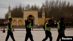 在中国新疆喀什艾提尕尔清真寺前走过一队巡逻的警察。 （资料照片）