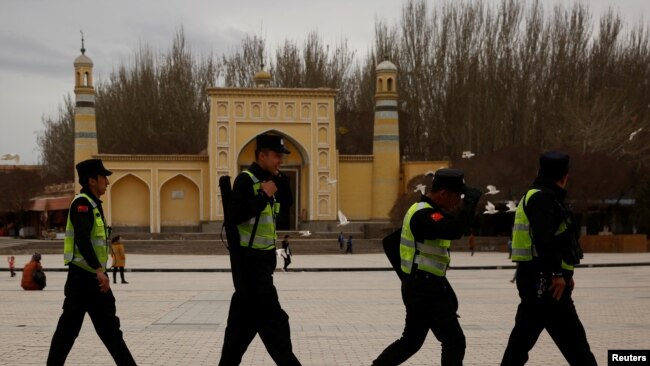 在中国新疆喀什艾提尕尔清真寺前走过一队巡逻的警察。 (资料照片)