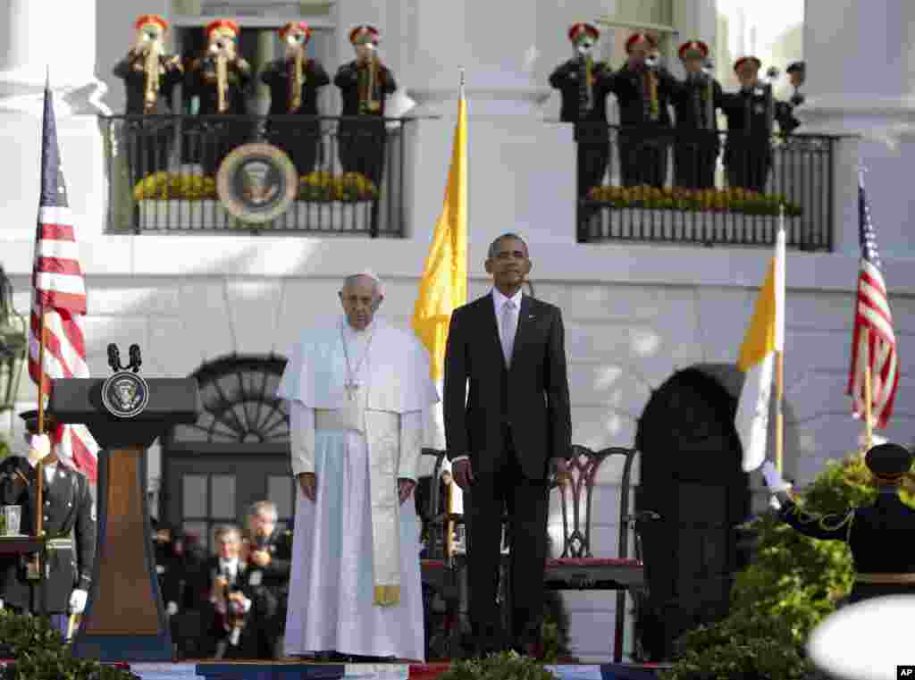 Presiden AS Barack Obama dan Paus Fransiskus dalam sikap sempurna saat lagu kebangsaan kedua negara dikumandangkan di lapangan rumput selatan Gedung Putih di Washington (23/9). (AP/Pablo Martinez Monsivais)