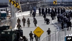U.S. military personnel and Customs and Border Protection officers gather along the southbound lanes of the San Ysidro port of entry, Nov. 25, 2018, in San Diego, California, at the U.S. border with Mexico.
