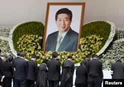 FILE - Family members of former South Korean president Roh Moo-hyun bow for Roh in a funeral service at the Gyeongbok Palace near the presidential Blue House in Seoul, May 29, 2009.