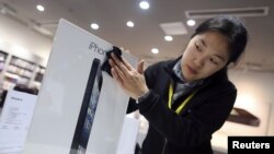 2012年12月，在武汉的苹果产品专卖店里，职工在清洁广告牌
