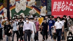 People wearing masks against the spread of the new coronavirus walk at Shibuya pedestrian crossing in Tokyo Friday, July 31, 2020. The Japanese capital confirmed Friday more than 400 new coronavirus cases. (AP Photo/Eugene Hoshiko)