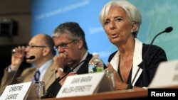 IMF Managing Director Christine Lagarde (R) speaks at a conference after the release of IMF's annual report on the U.S. economy in Washington, July 3, 2012. 