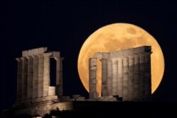 Bulan purnama tampak di belakang kuil Poseidon, di Cape Sounion, dekat Athena, salah satu tempat yang menjadi tujuan wisata di Yunani (foto: dok).