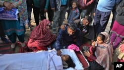 Relatives of an Indian woman who was killed in Pakistani firing and shelling wail over her body at a hospital in the Ranbir Singh Pura district of Jammu and Kashmir, India, Jan. 19, 2018.