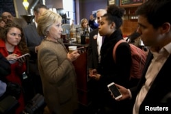 FILE - U.S. Democratic presidential candidate Hillary Clinton has an exchange with a young woman asking questions about issues pertaining to the Somali-American community as she greets people at Mapps Coffee in Minneapolis, Minnesota, March 1, 2016.