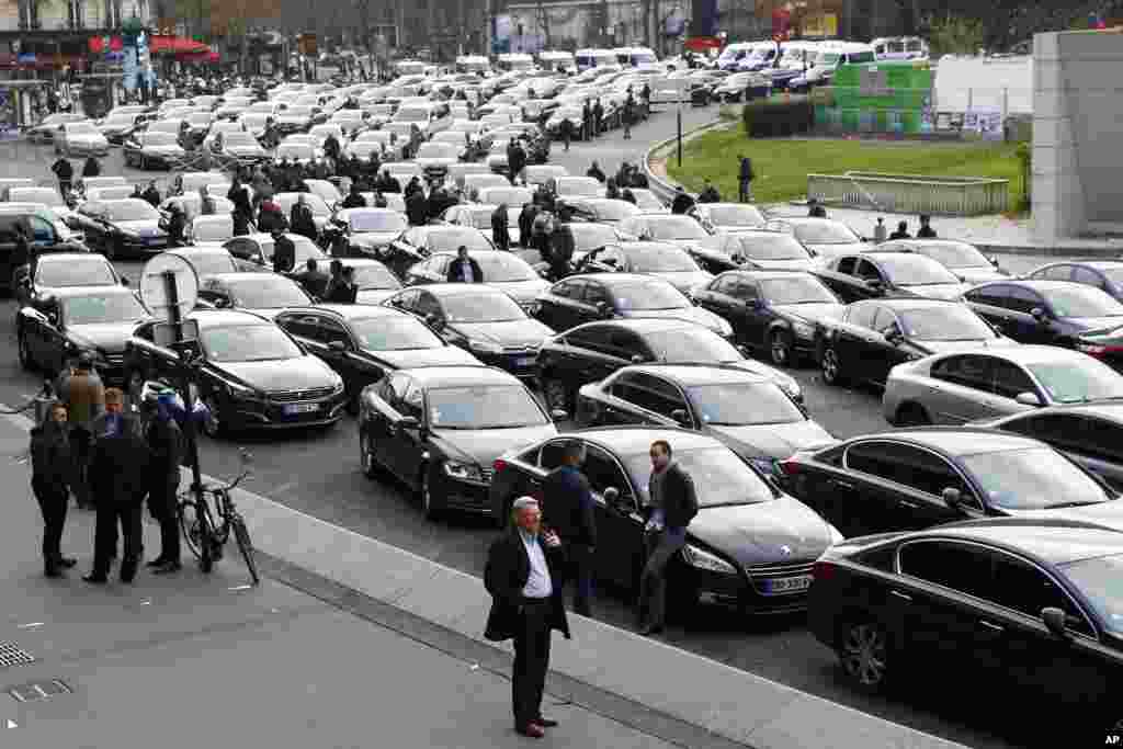 French livery drivers block traffic during "Snail Operation" at Port Maillot, one of the entries to Paris. Drivers are protesting a drop in their rates, striking out again, against what they say is unfair competition by Uber and other companies.