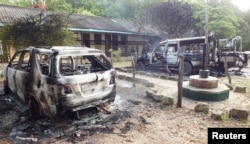 FILE - Wreckages of burnt cars are seen outside the Mpeketoni police station after gunmen attacked the coastal Kenyan town, June 16, 2014.