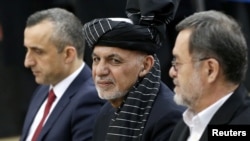 FILE - Afghanistan's President Ashraf Ghani, alongside his two vice president candidates, Amrullah Saleh, left, and Sarwar Danish, arrives to register as a candidate for the presidential election at Afghanistan's Independent Election Commission in Kabul, Jan. 20, 2019.