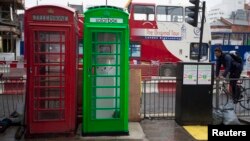 Una cabina solar verde junto a una normal en el centro de Londres.