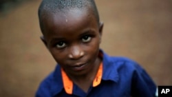 FILE - Shardrack Bahati, eight, sits outside his room at the En Avant Les Enfants INUKA center in Goma, Democratic Republic of Congo.