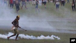 An indigenous man runs amid tear gas fired by police during a protest for the demarcation of indigenous lands outside the National Congress in Brasilia, Brazil, April 25, 2017. 