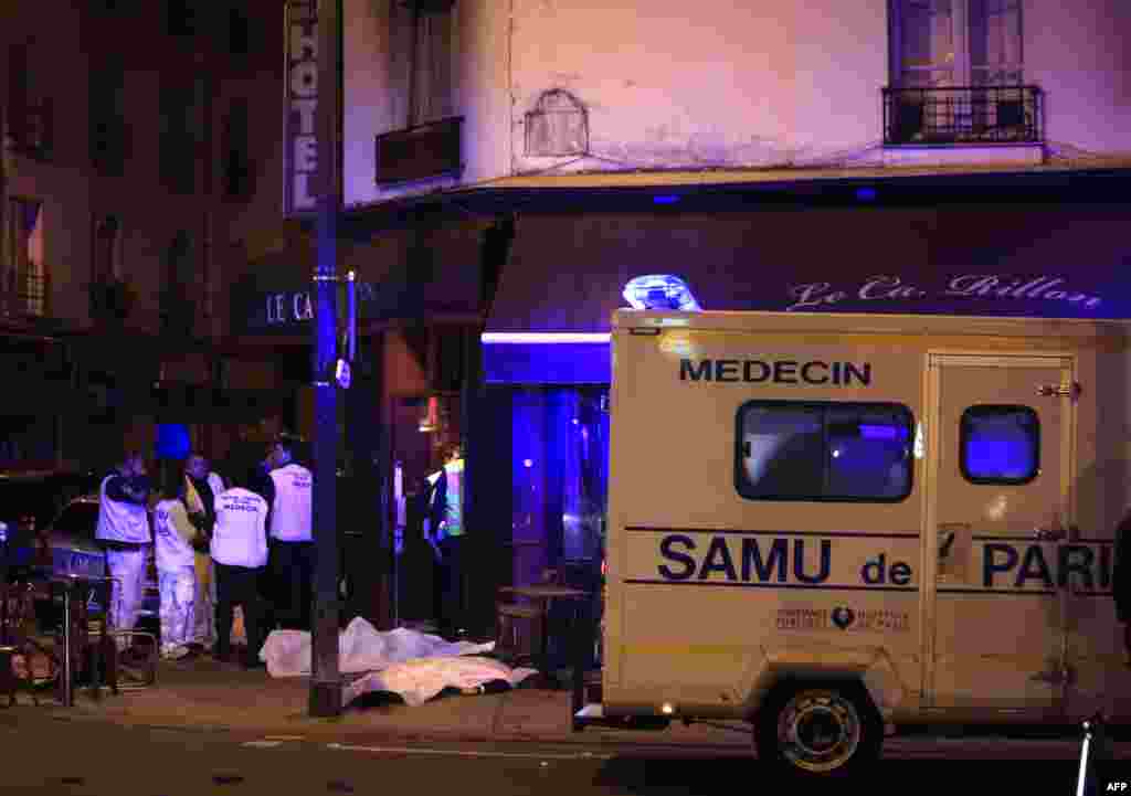 Equipa médica junto das vítimas de tiroteio no restaurante Petit Cambodge, Paris, Nov. 13, 2015.