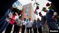 People hold hands as they sing and pray at a makeshift memorial at Dallas Police Headquarters following the multiple police shootings in Dallas, Texas, U.S., July 9, 2016. 