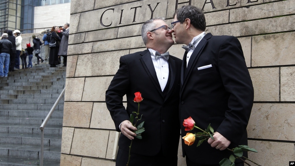 FILE - Terry Gilbert, left, kisses his husband Paul Beppler after wedding at Seattle City Hall, becoming among the first gay couples to legally wed in the state, December 9, 2012. 