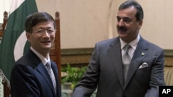 Chinese Public Security Minister Meng Jianzhu, left, shakes hands with Pakistan's Prime Minister Yusuf Raza Gilani in Islamabad, Pakistan, September 27, 2011.